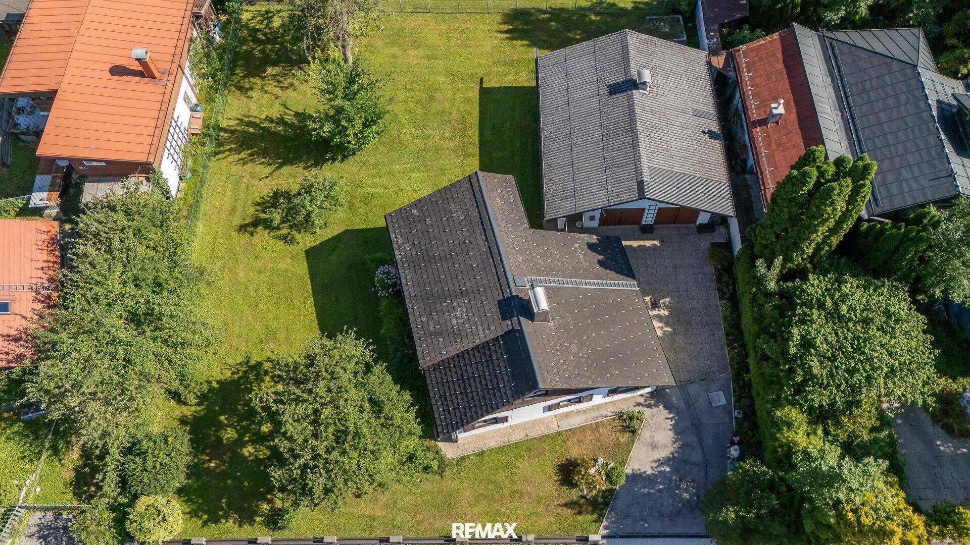 Vogelperspektive des Hauses mit angrenzender Garage, großem Garten und Zufahrt.