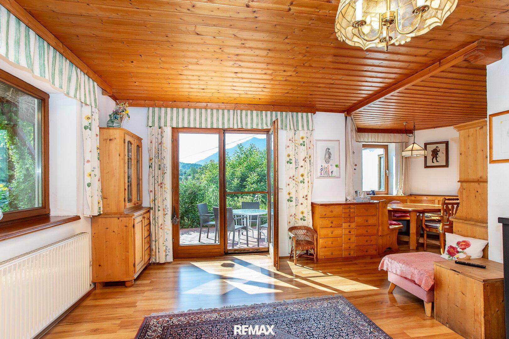 Gemütlicher Wohn-Essbereich mit Holzbalkendecke, Parkettboden und Zugang zur Terrasse.