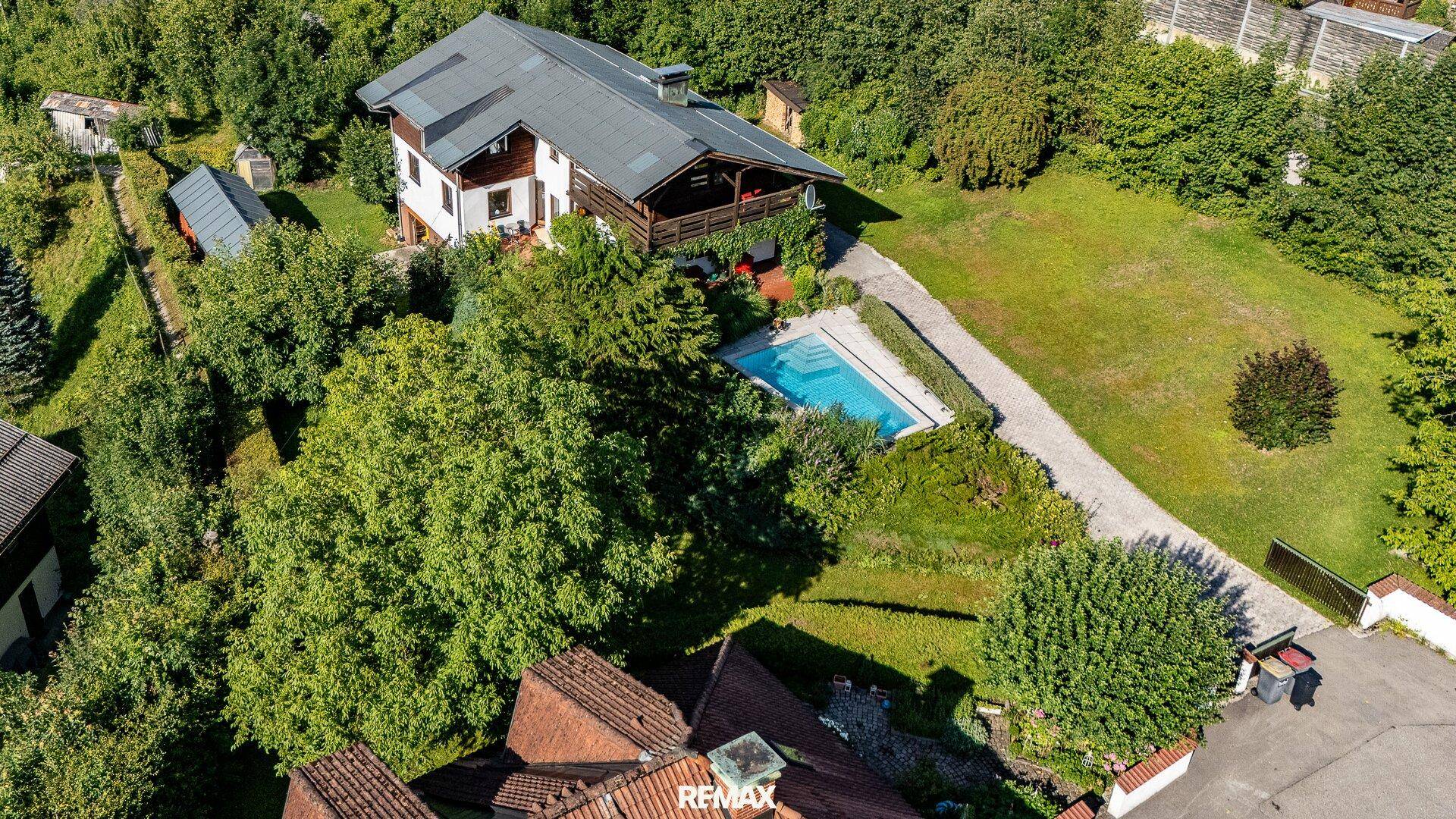Weitläufiges Grundstück mit Einfamilienhaus, Pool und großem Garten aus der Vogelperspektive.