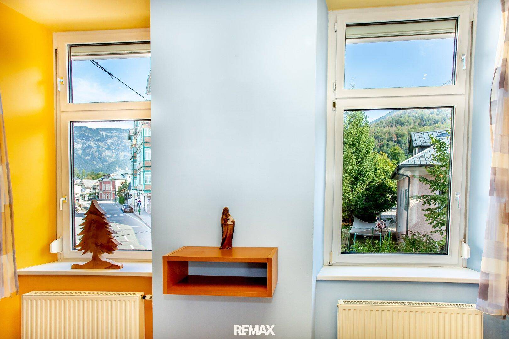 Fenster mit Blick auf die Berge und die grüne Umgebung, helle Räume.