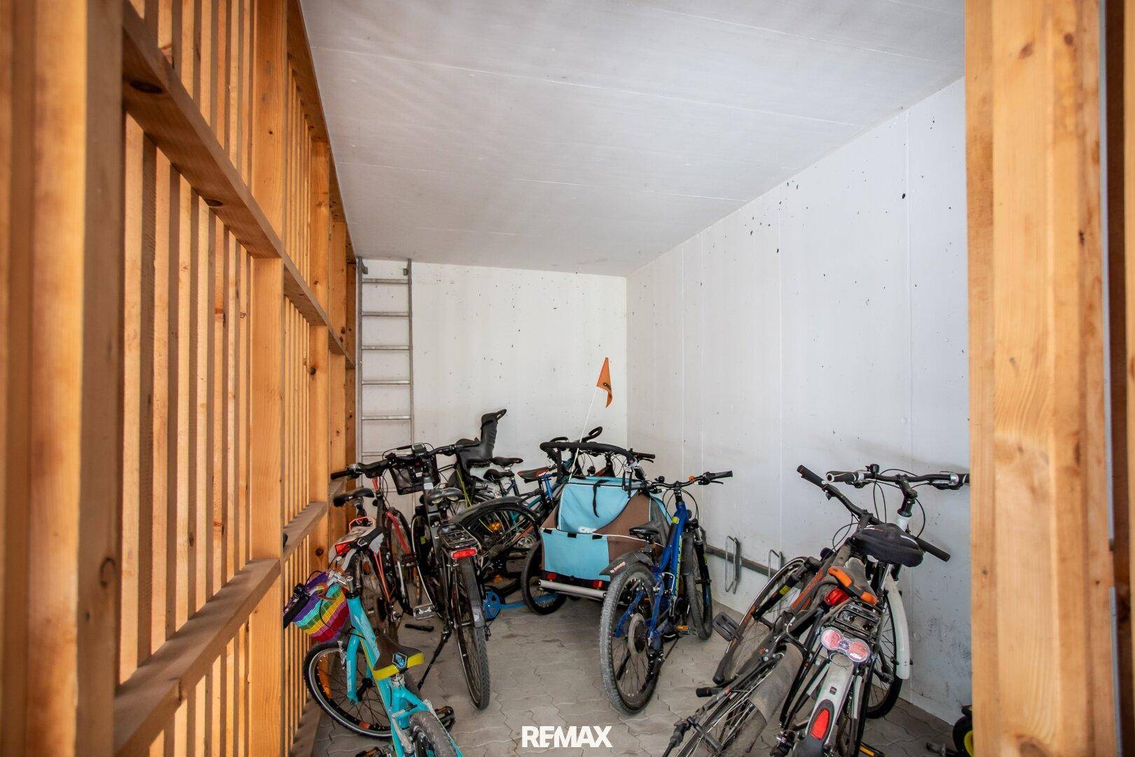 Fahrradraum mit Holzlattenwänden und mehreren Fahrrädern abgestellt.