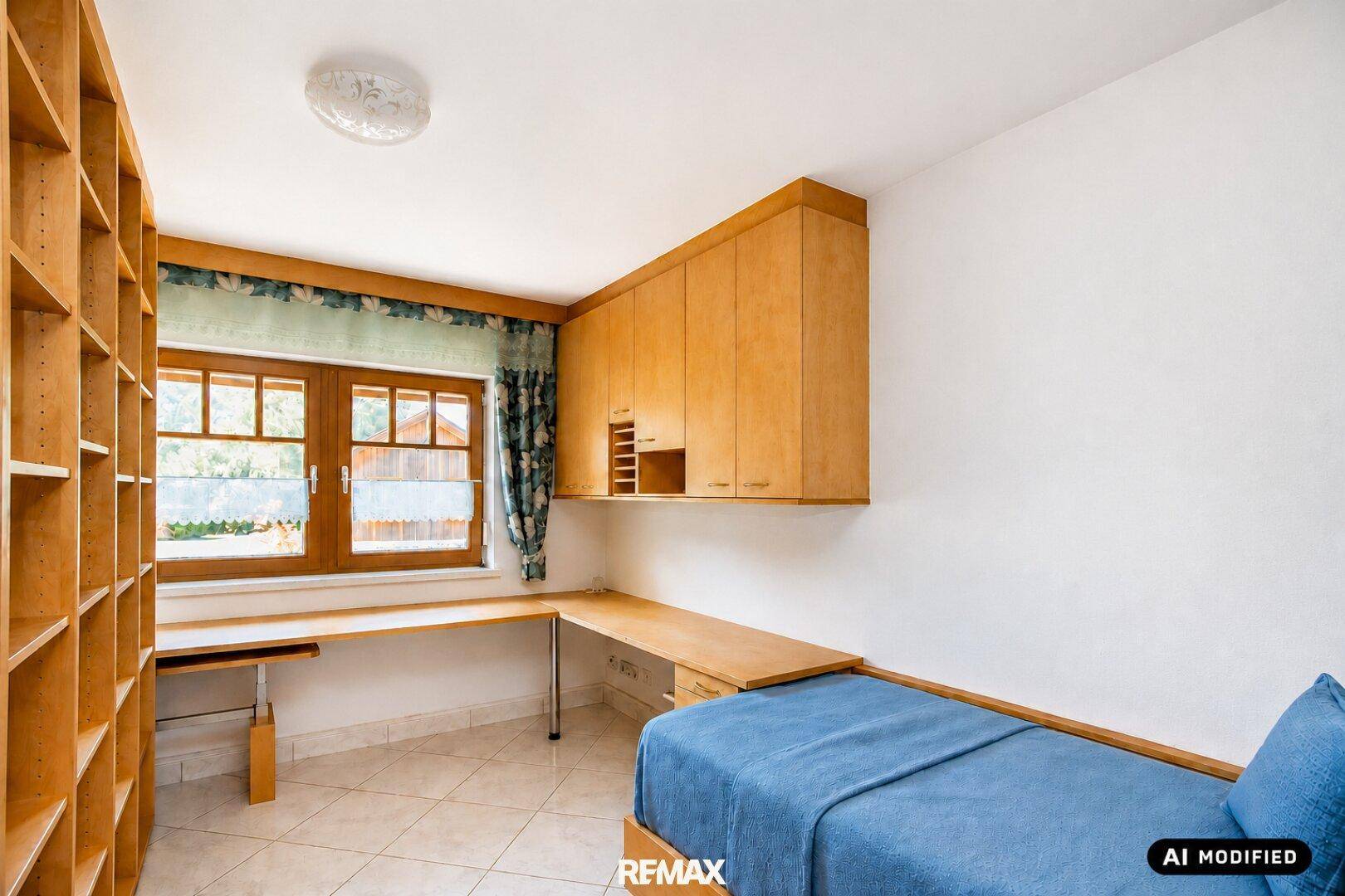 Helles Arbeitszimmer mit Holzmöbeln, Regalwand und Fenster mit Blick nach draußen.