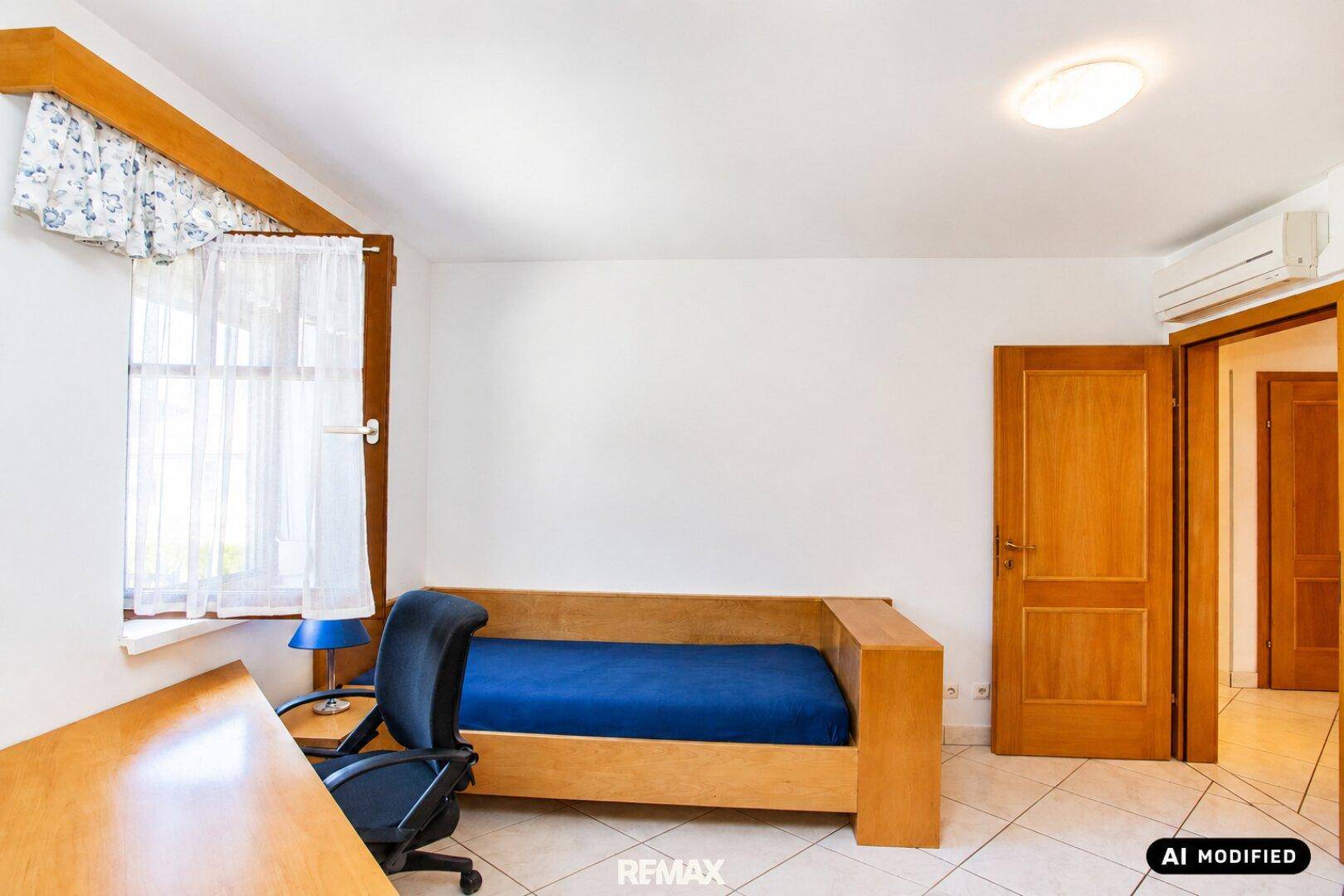 Helles Zimmer mit Schlafsofa, Schreibtisch und Klimaanlage für angenehmes Raumklima.