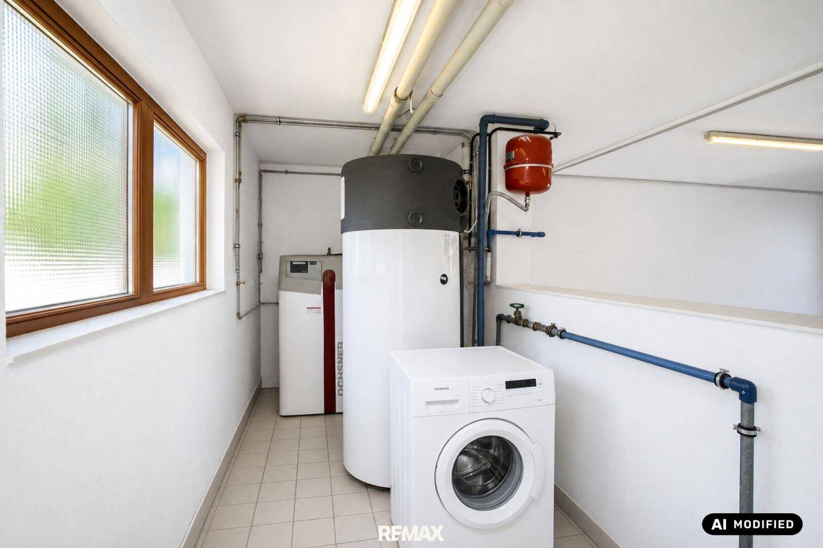 Hauswirtschaftsraum mit Waschmaschine, Warmwasserspeicher und Fenster für Belüftung.