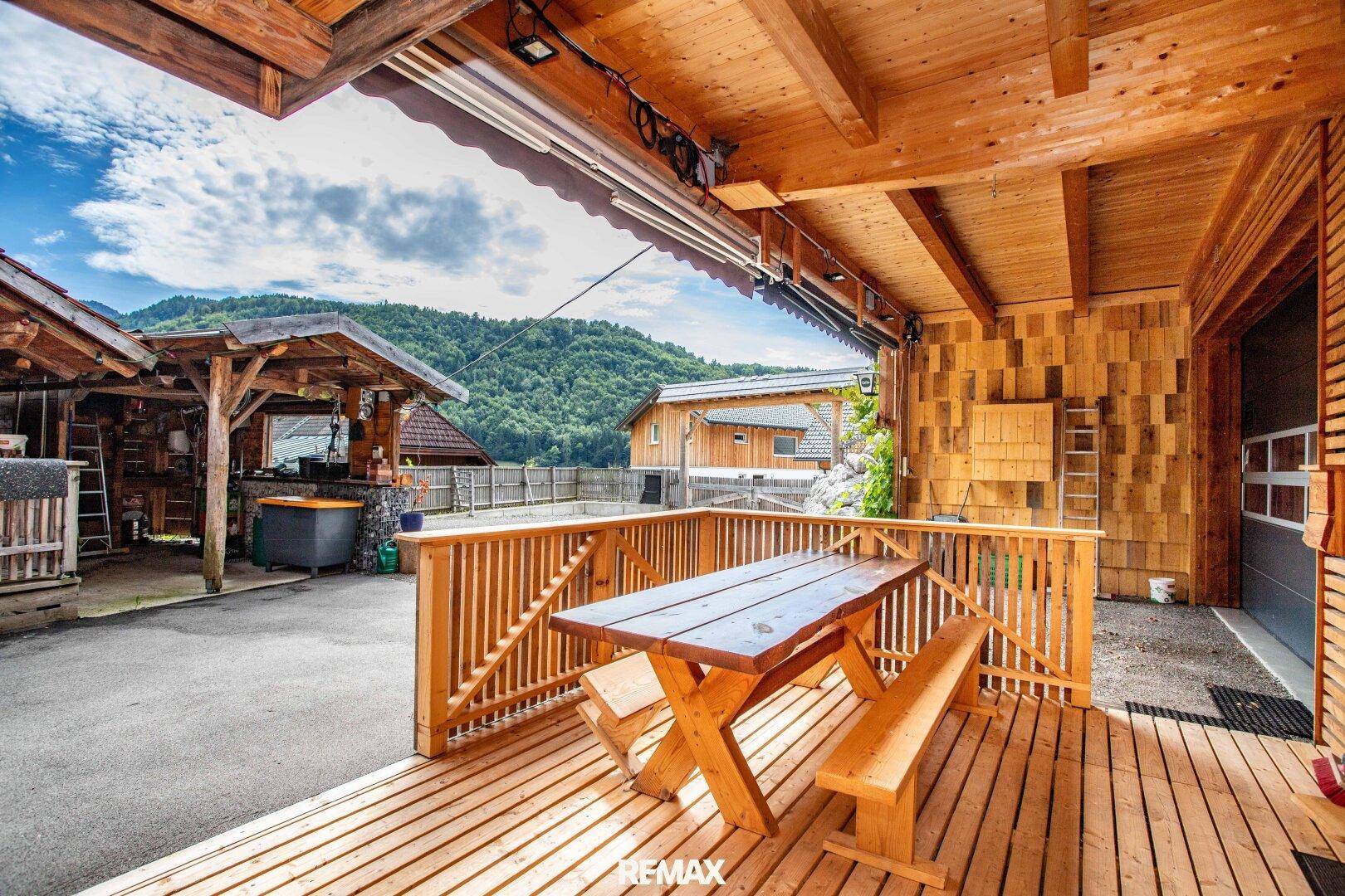 Holzterrasse mit Picknicktisch und Bänken, ideal für Mahlzeiten im Freien mit Bergblick.
