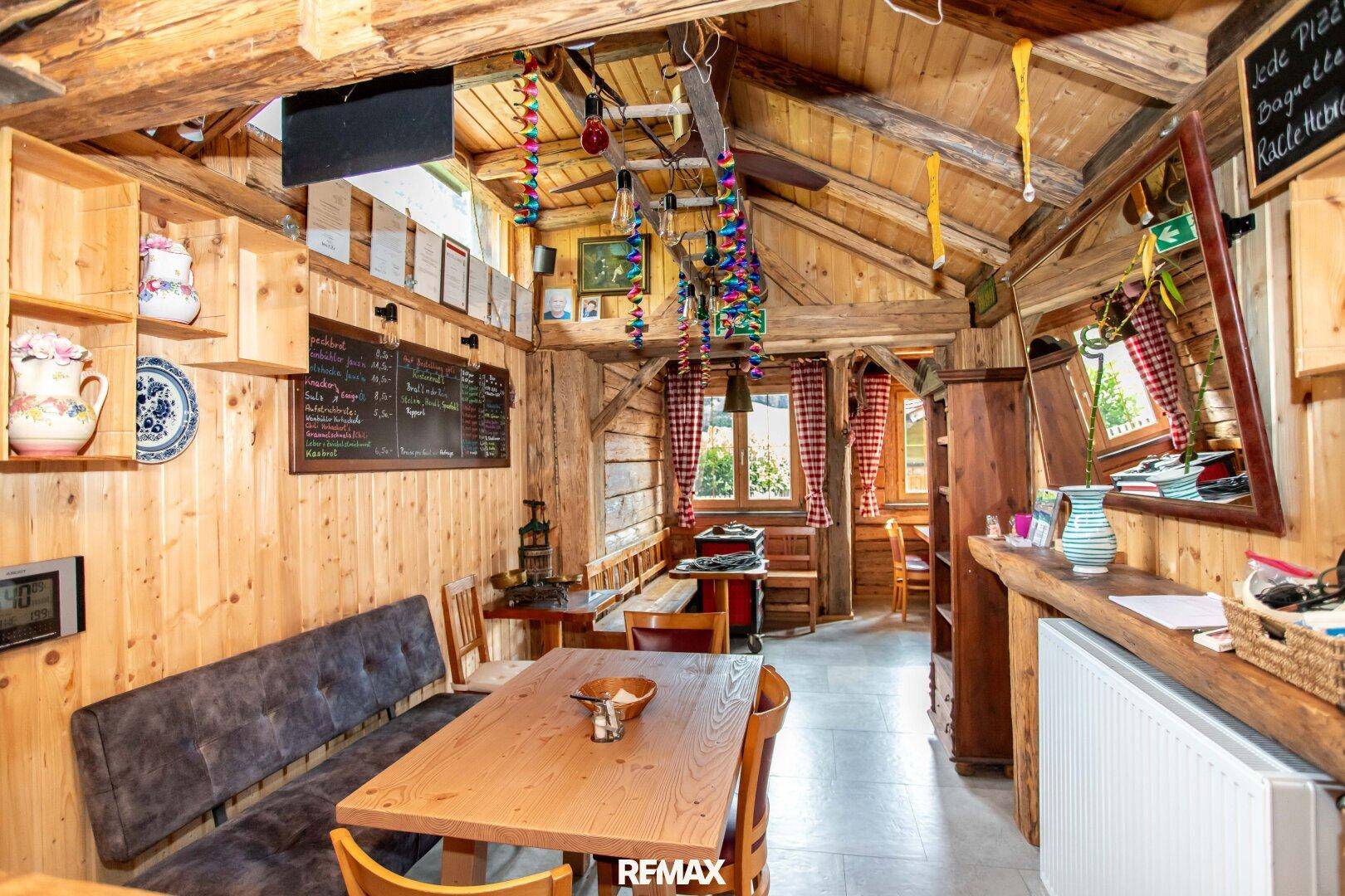 Gemütlicher Ess- und Loungebereich mit Holzbänken und traditioneller Dekoration.