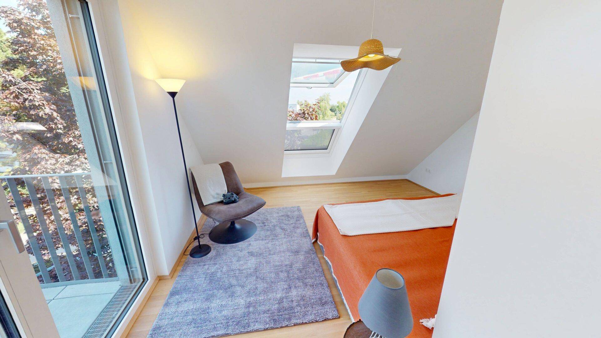 Gemütliches Schlafzimmer im Dachgeschoss mit Zugang zur Terrasse und viel Tageslicht.