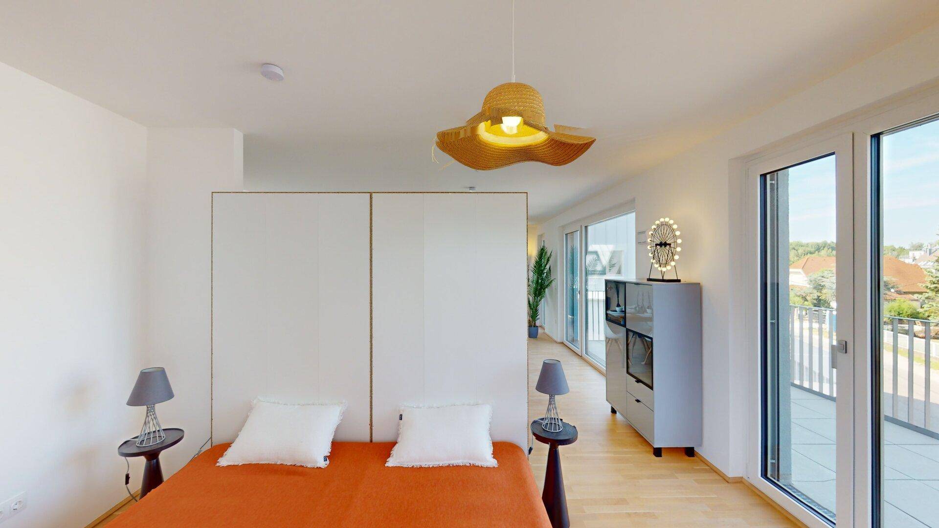 Helles Schlafzimmer mit Einbauschränken und direktem Zugang zur großen Dachterrasse.