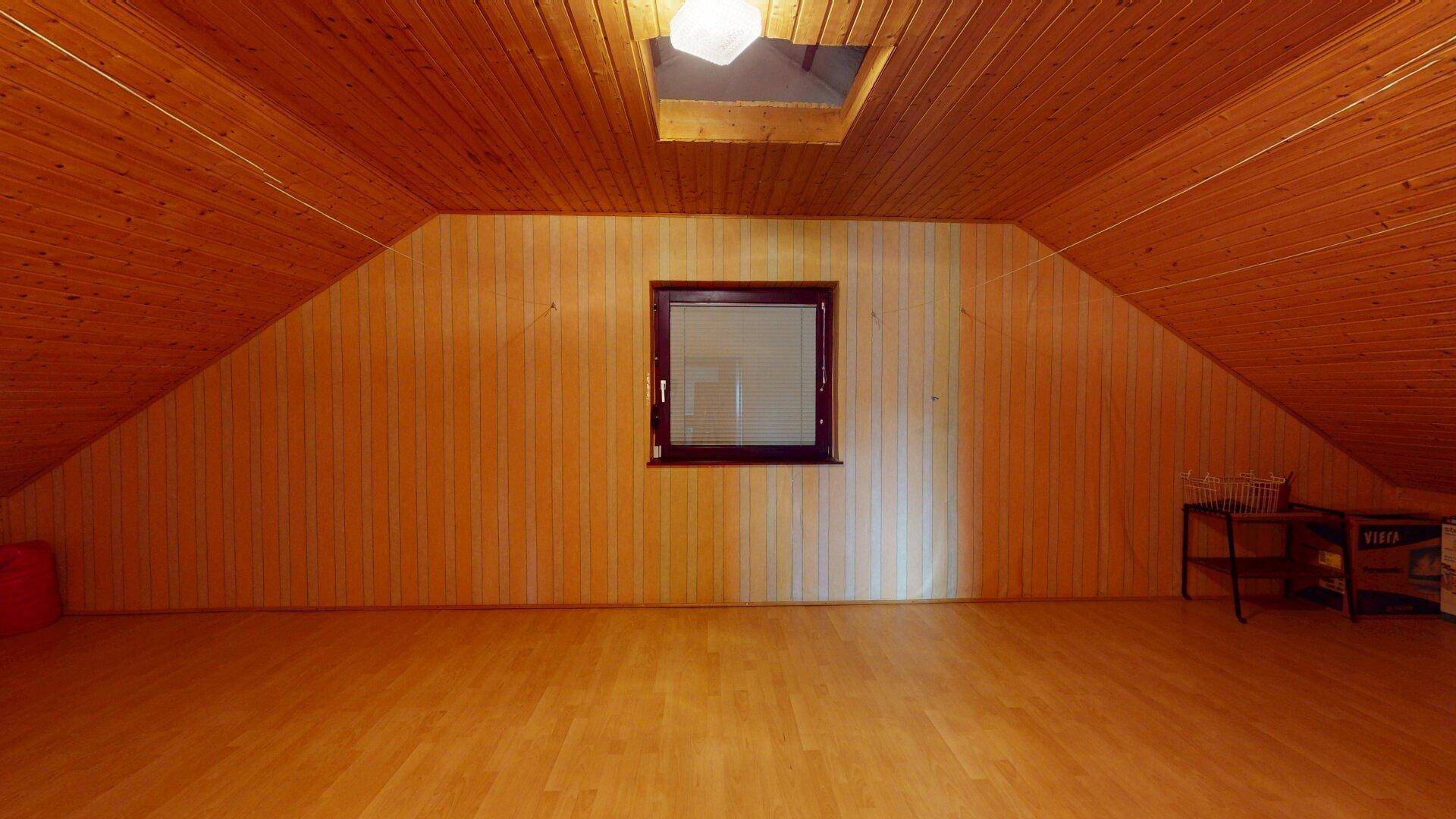 Heller Dachboden mit Holzvertäfelung, Dachfenster und viel Stauraum.
