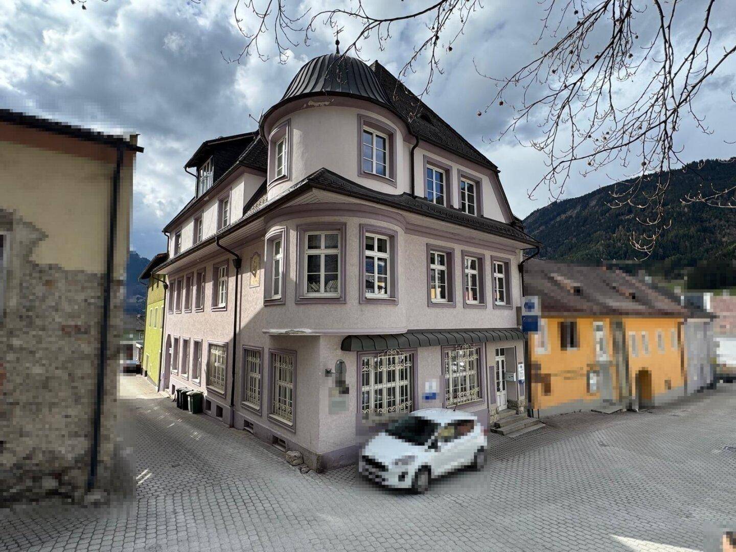 Historisches Gebäude mit runden Erkern und traditioneller Architektur in einer städtischen Gasse.