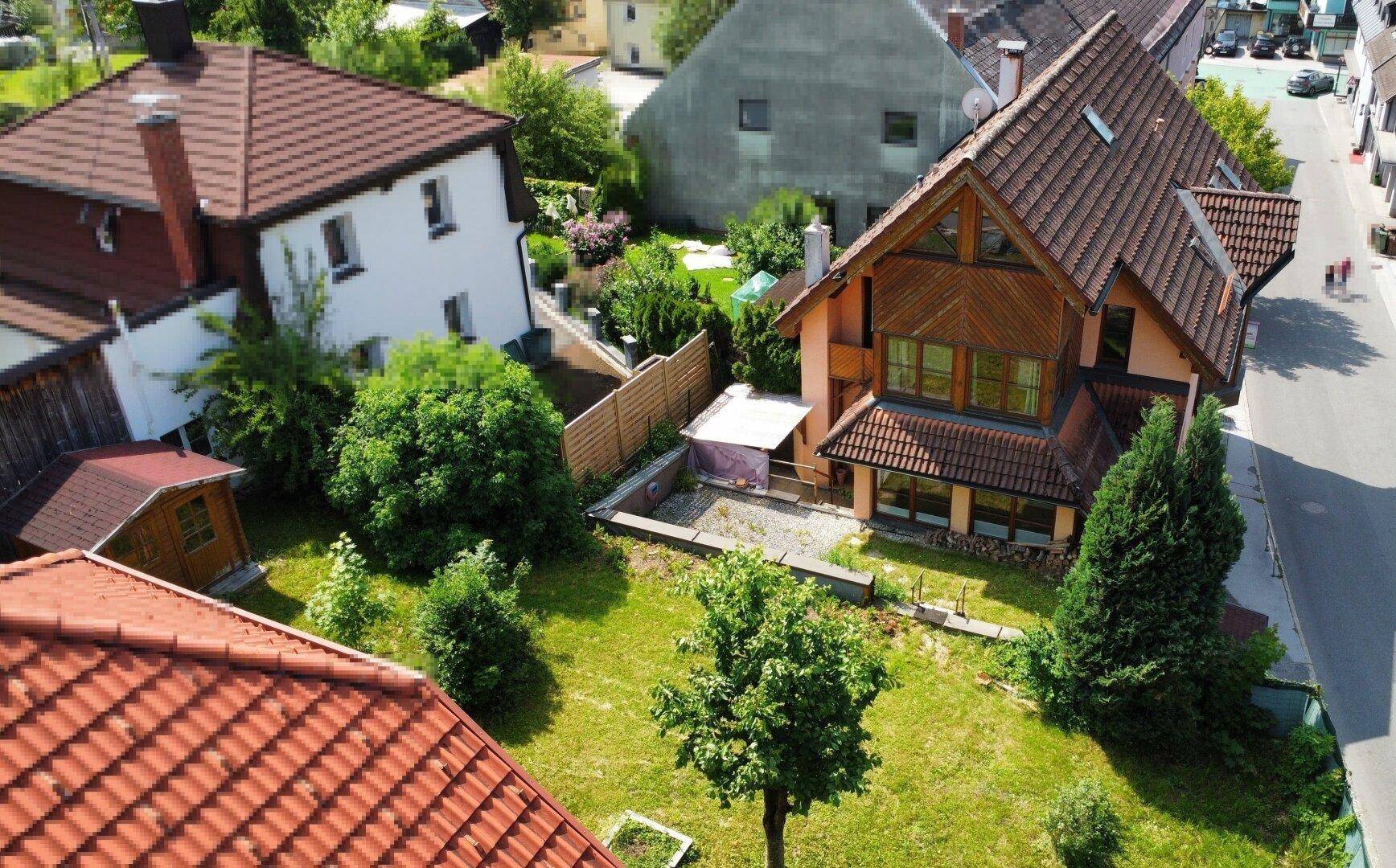 Luftaufnahme eines Hauses mit großem Garten und umliegenden Gebäuden in ländlicher Umgebung.