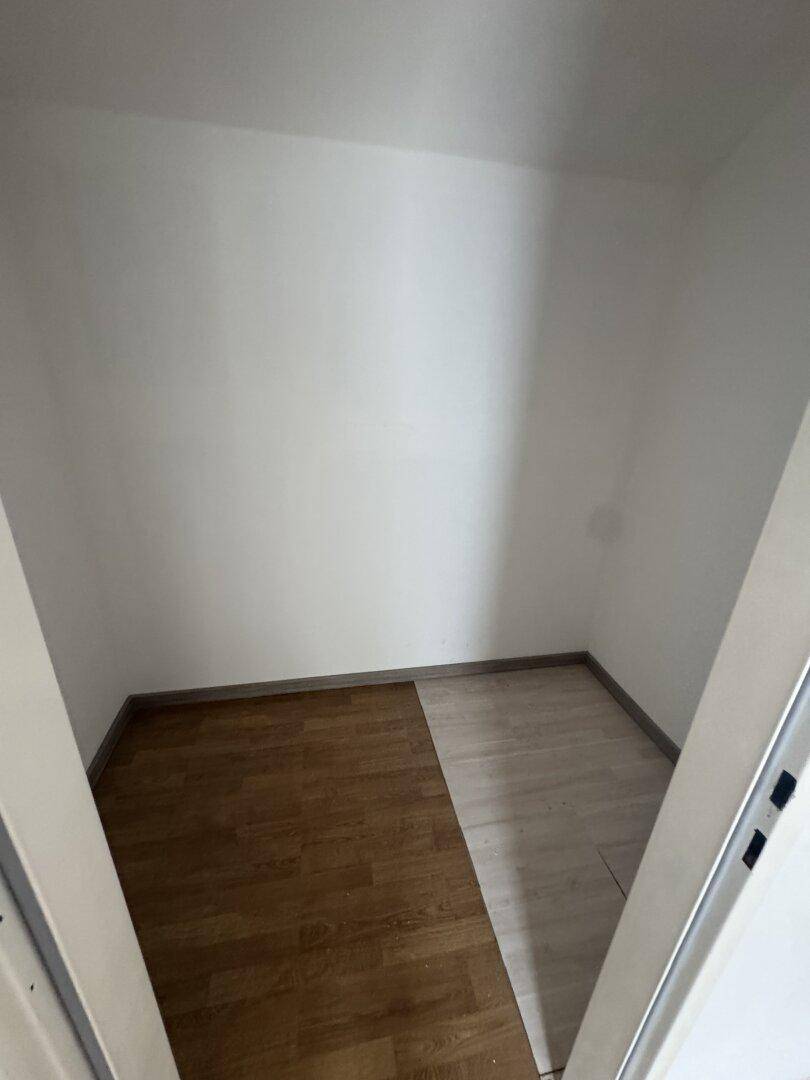 Kleiner Raum mit unterschiedlichen Bodenbelägen, ideal als Abstellraum oder begehbarer Kleiderschrank.