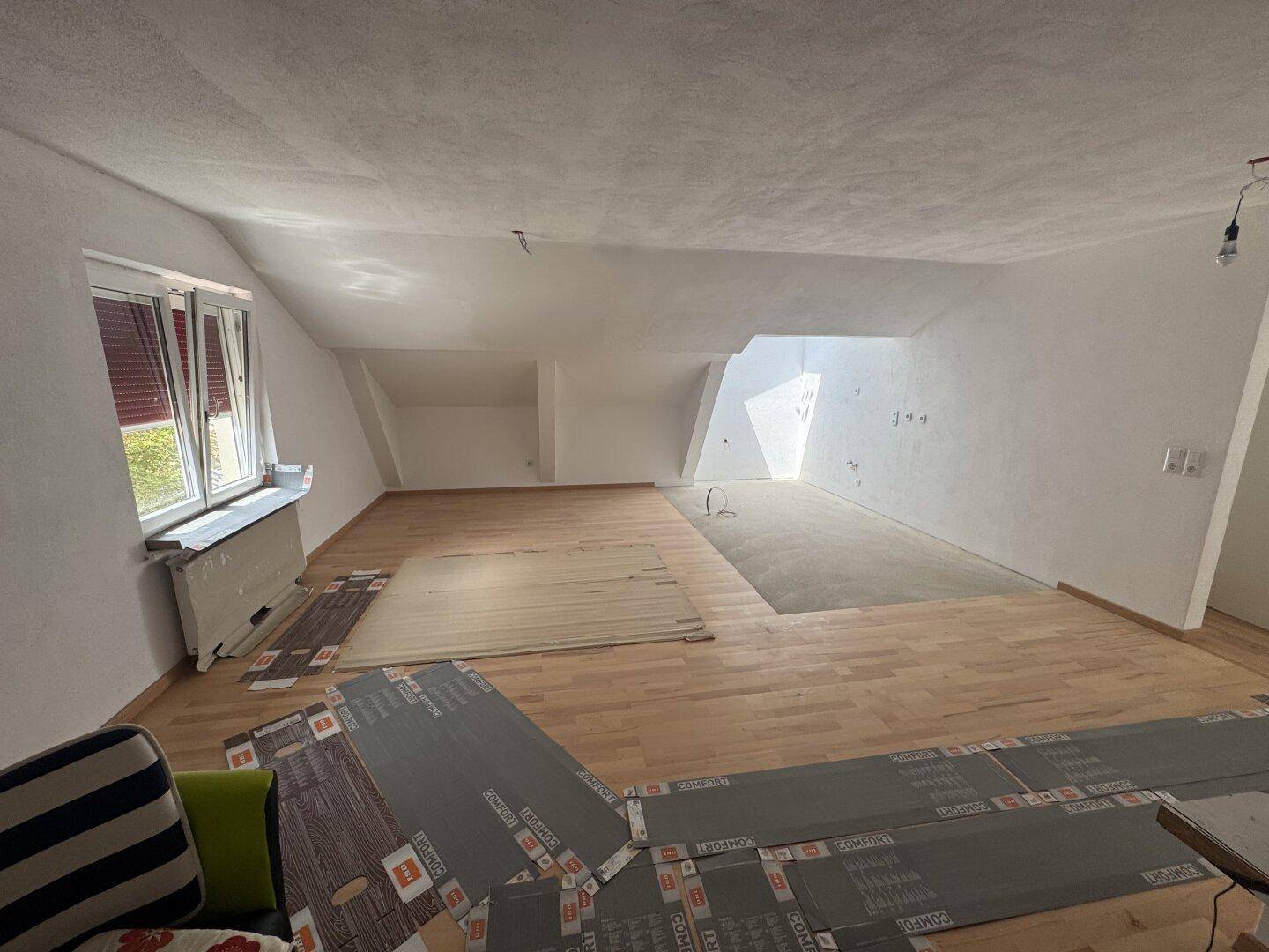 Großzügiger Wohnbereich im Dachgeschoss mit Holzboden und viel Tageslicht.