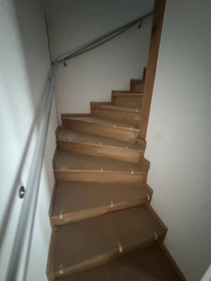 Holztreppe mit Schutzabdeckung, die zu den oberen Etagen des Hauses führt.