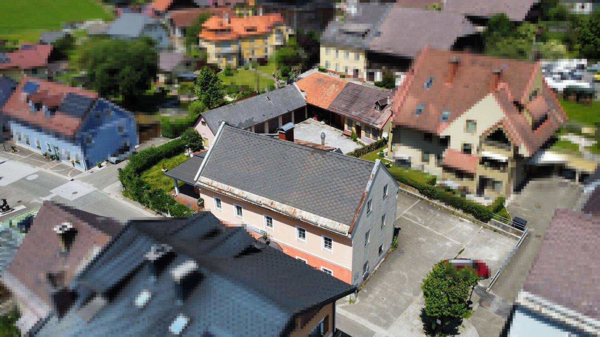 Luftaufnahme des Anwesens mit umliegenden Gebäuden und Dächern in einer ländlichen Umgebung.