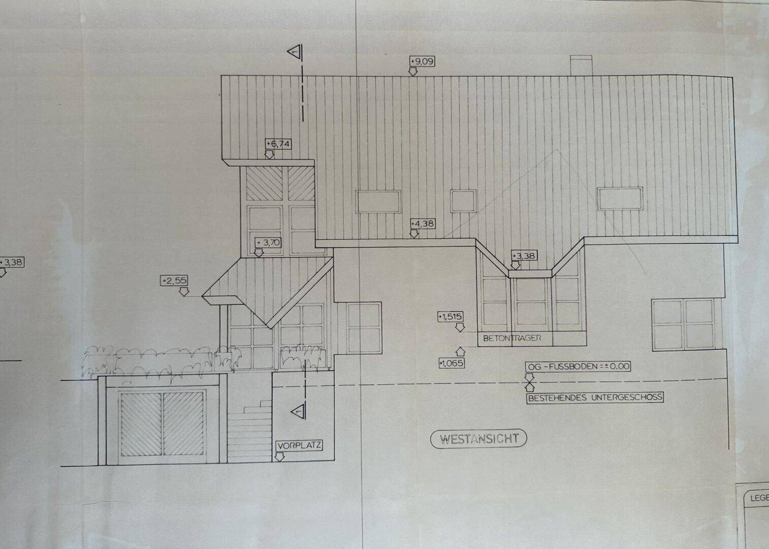 Architektonische Westansicht des Gebäudes mit Garage und mehreren Fenstern.