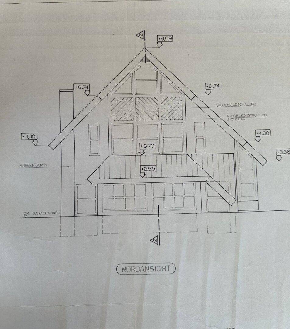 Architektonische Nordansicht des Hauses mit markantem Giebeldach und großen Fensterflächen.