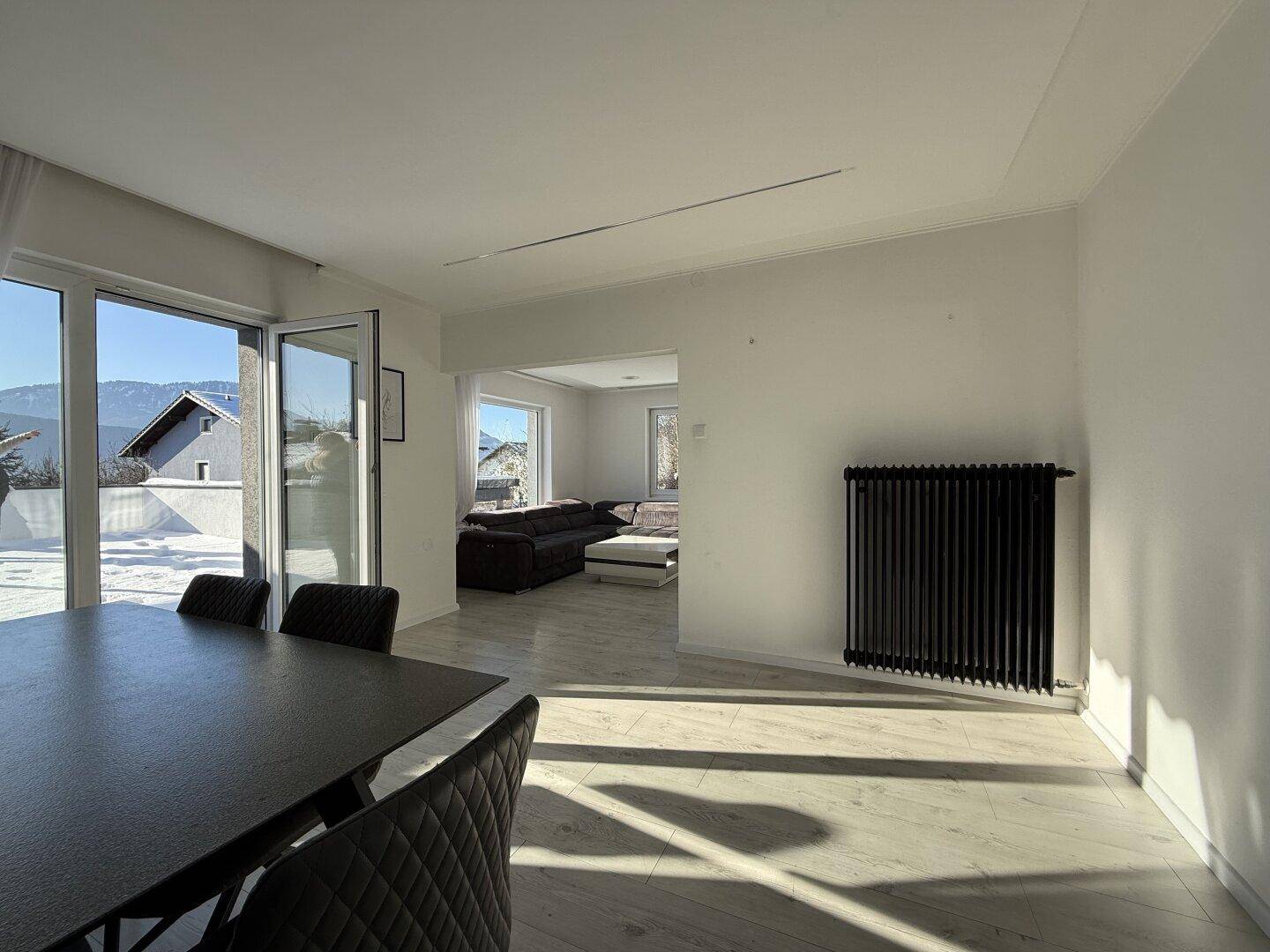 Heller Essbereich mit Zugang zur Terrasse und offenem Übergang zum Wohnzimmer.