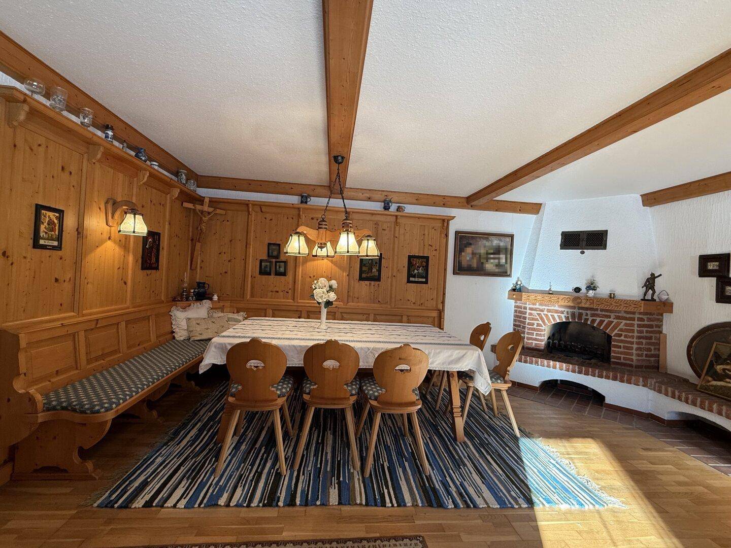 Rustikaler Essbereich mit gemauertem Kamin, Holzbalken und traditioneller Einrichtung.