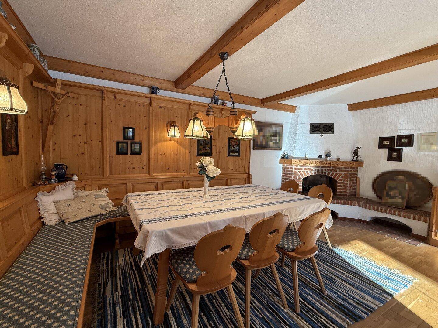 Geräumiger Essbereich mit Holztisch, Eckbank und gemauertem Kamin, ideal für gesellige Runden.