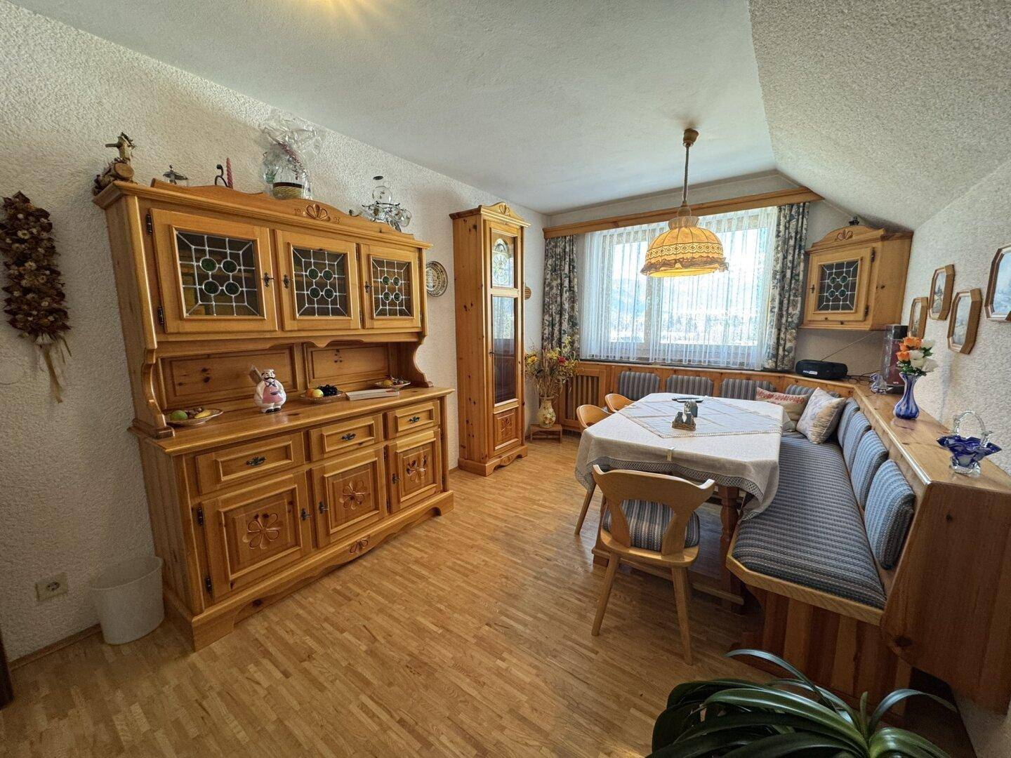 Gemütlicher Essbereich mit traditionellen Holzmöbeln, Eckbank und einem großen Buffetschrank.