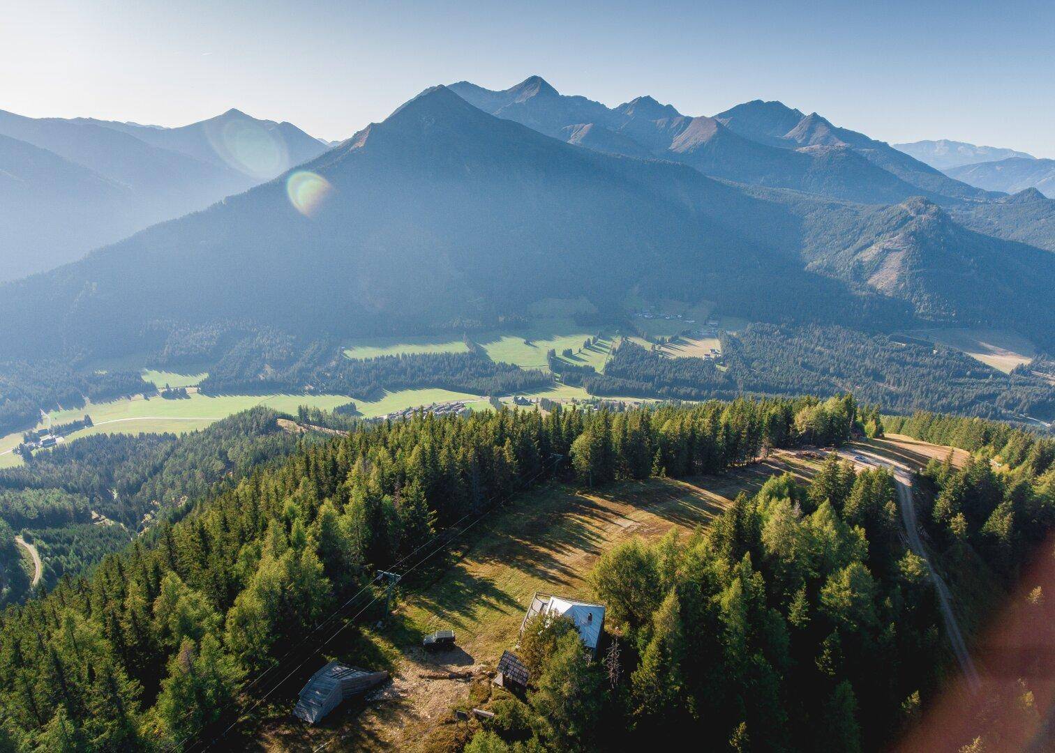 Malerische Berglandschaft im Sommer mit dichten grünen Wäldern und weiten Tälern.