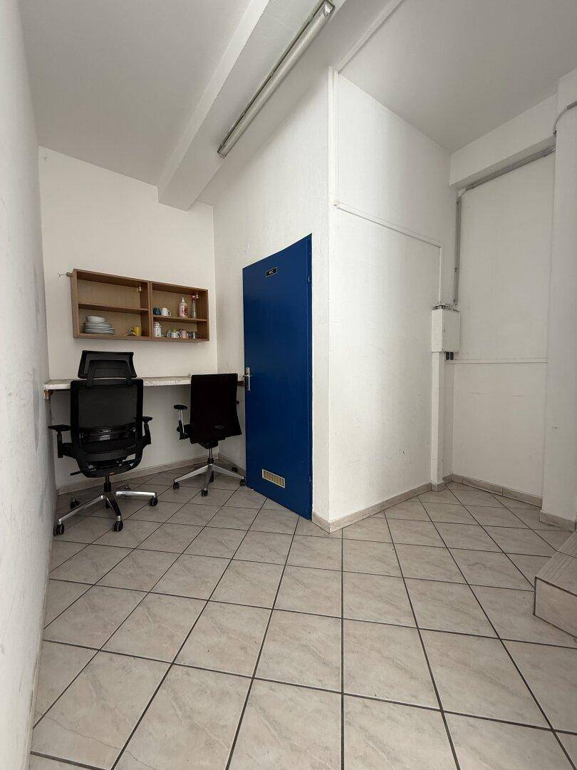 Kleinerer Raum mit Fliesenboden, zwei Bürostühlen und einem Regal, nutzbar als Arbeitsbereich.