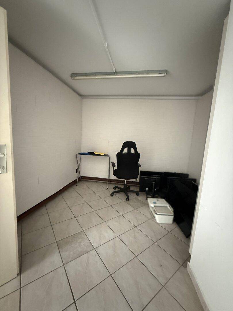 Kleineres, separates Büro mit Fliesenboden und einem Bürostuhl, geeignet als Einzelarbeitsplatz.