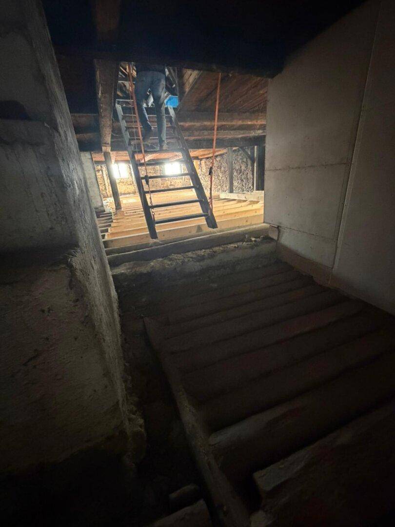 Dachboden mit Holztreppe und freiliegenden Holzbalken, bereit für den weiteren Ausbau.