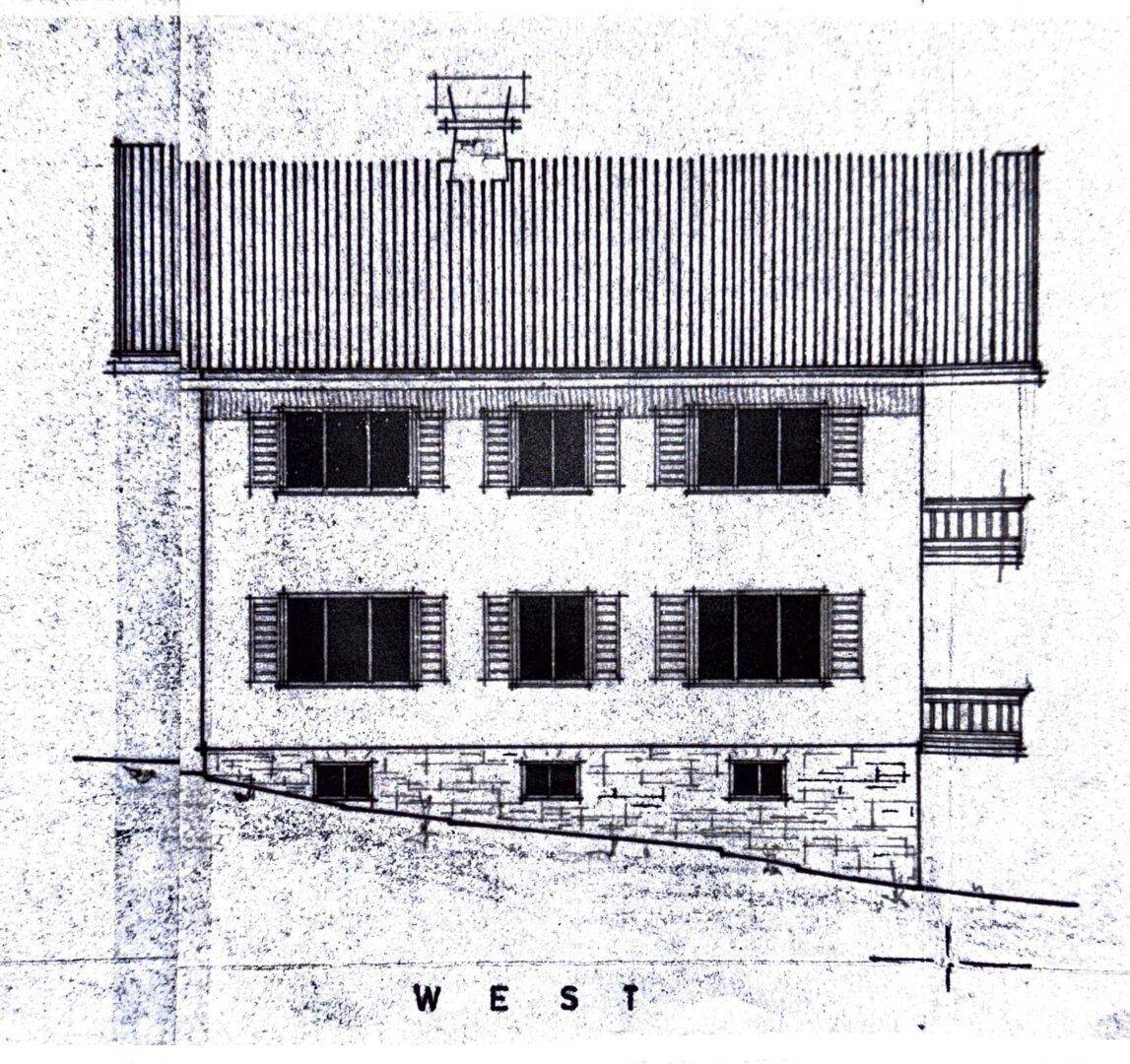 Westansicht des Gebäudes mit Fensterreihen und seitlichen Balkonen.