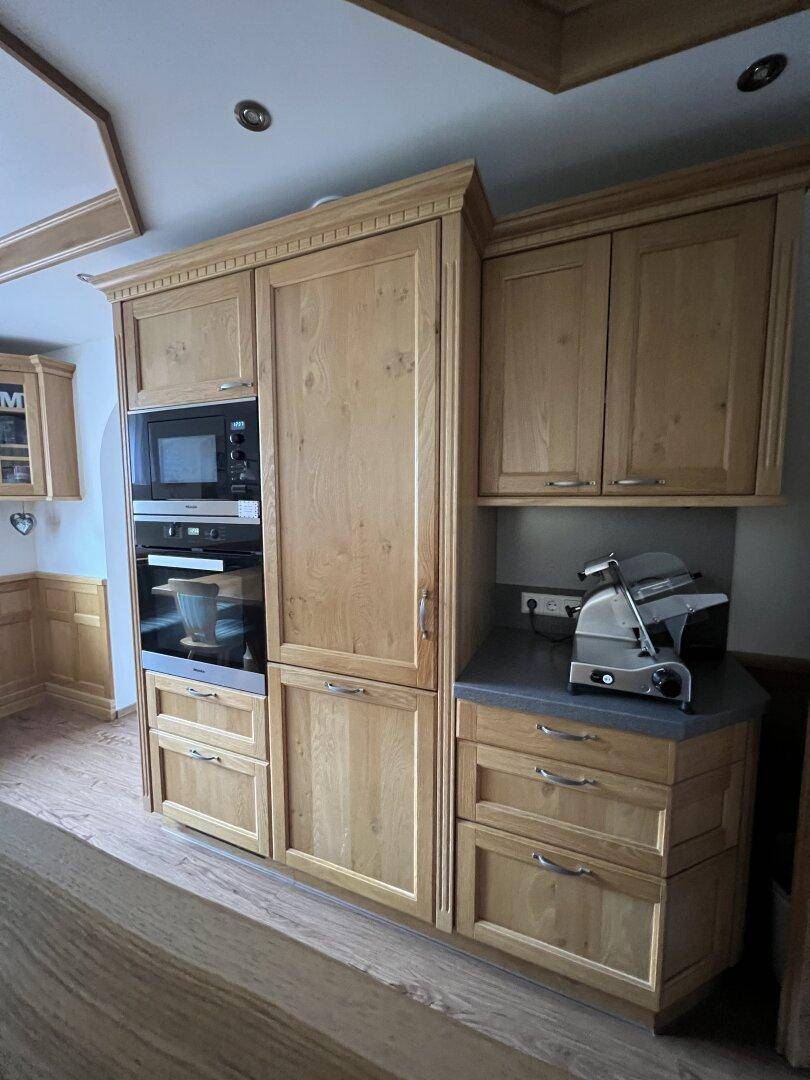 Einbauschränke in der Küche mit integrierter Mikrowelle, Backofen und Kühlschrank.