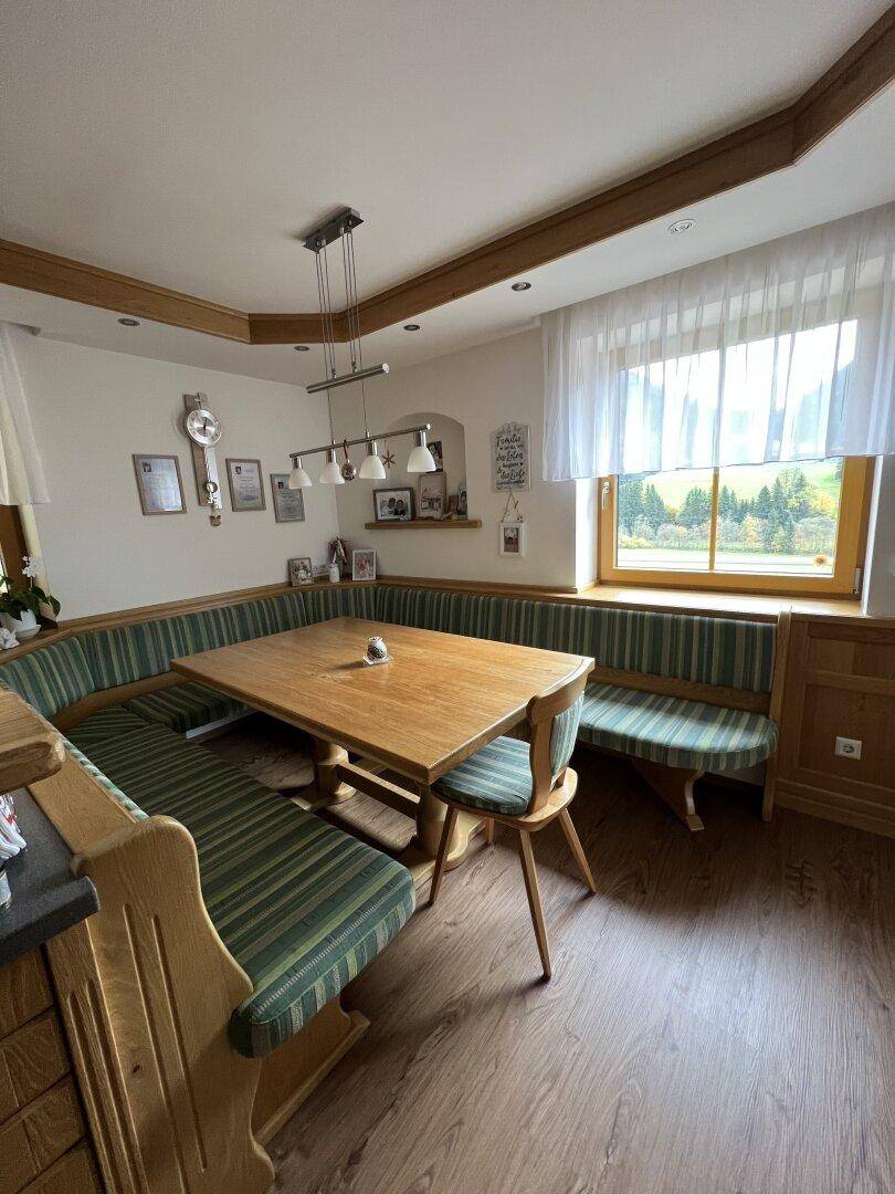 Gemütlicher Essbereich mit großem Holztisch und Eckbank, ideal für Familienmahlzeiten.