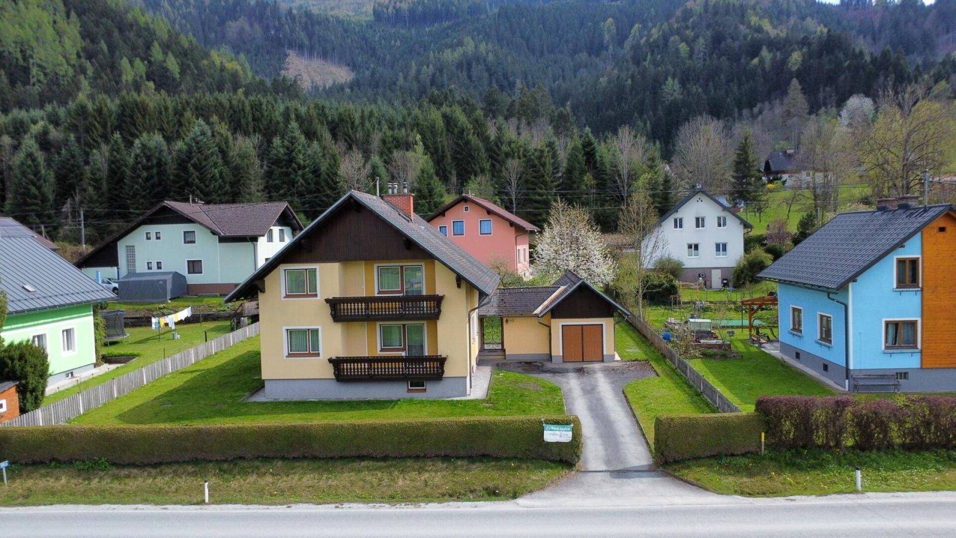 Übersicht der Wohnsiedlung mit Einfamilienhäusern, umgeben von Natur und Bergen.