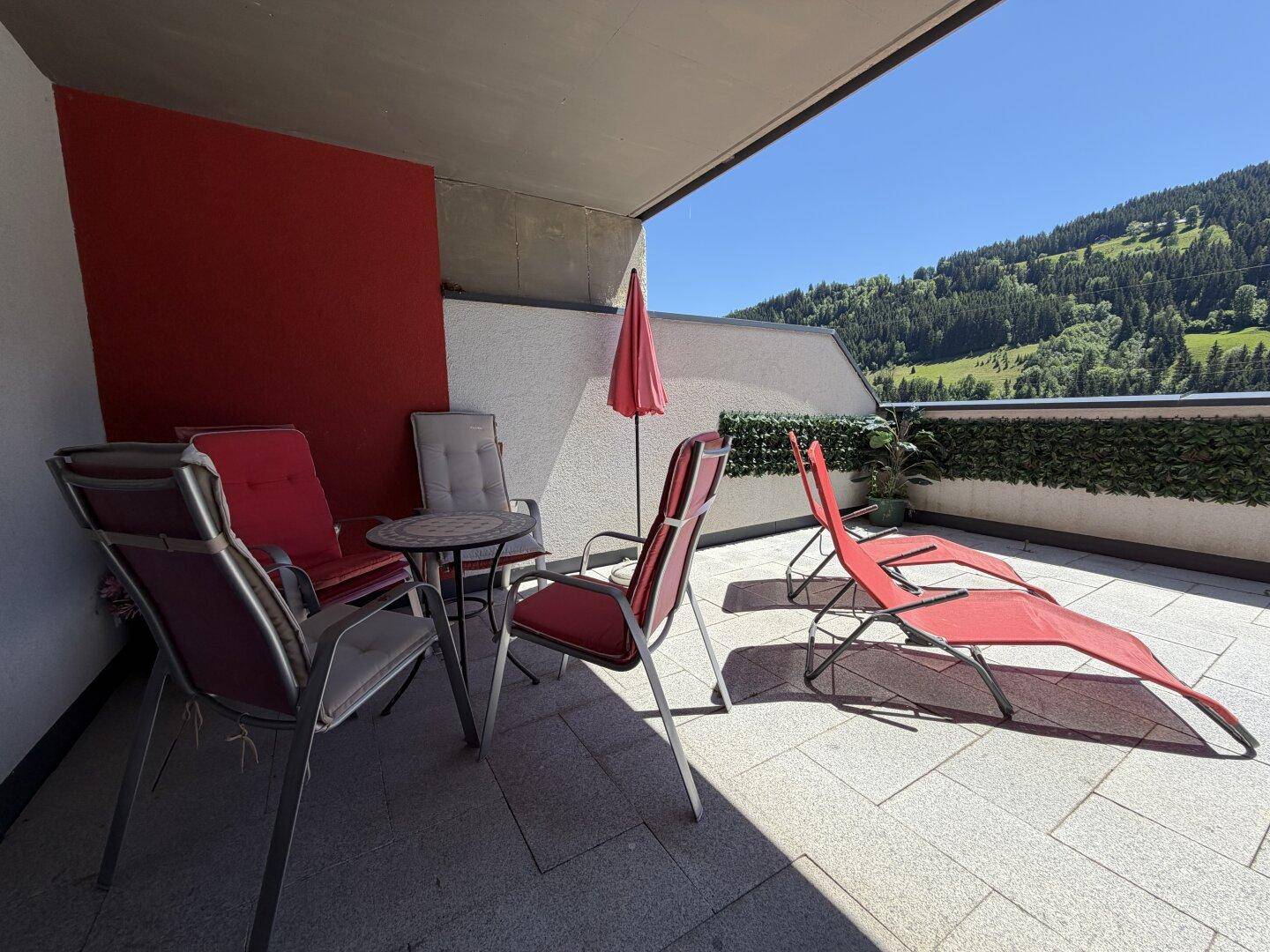 Gemütliche Terrasse mit Sitzgelegenheiten und Liegestühlen, ideal zum Entspannen im Freien.
