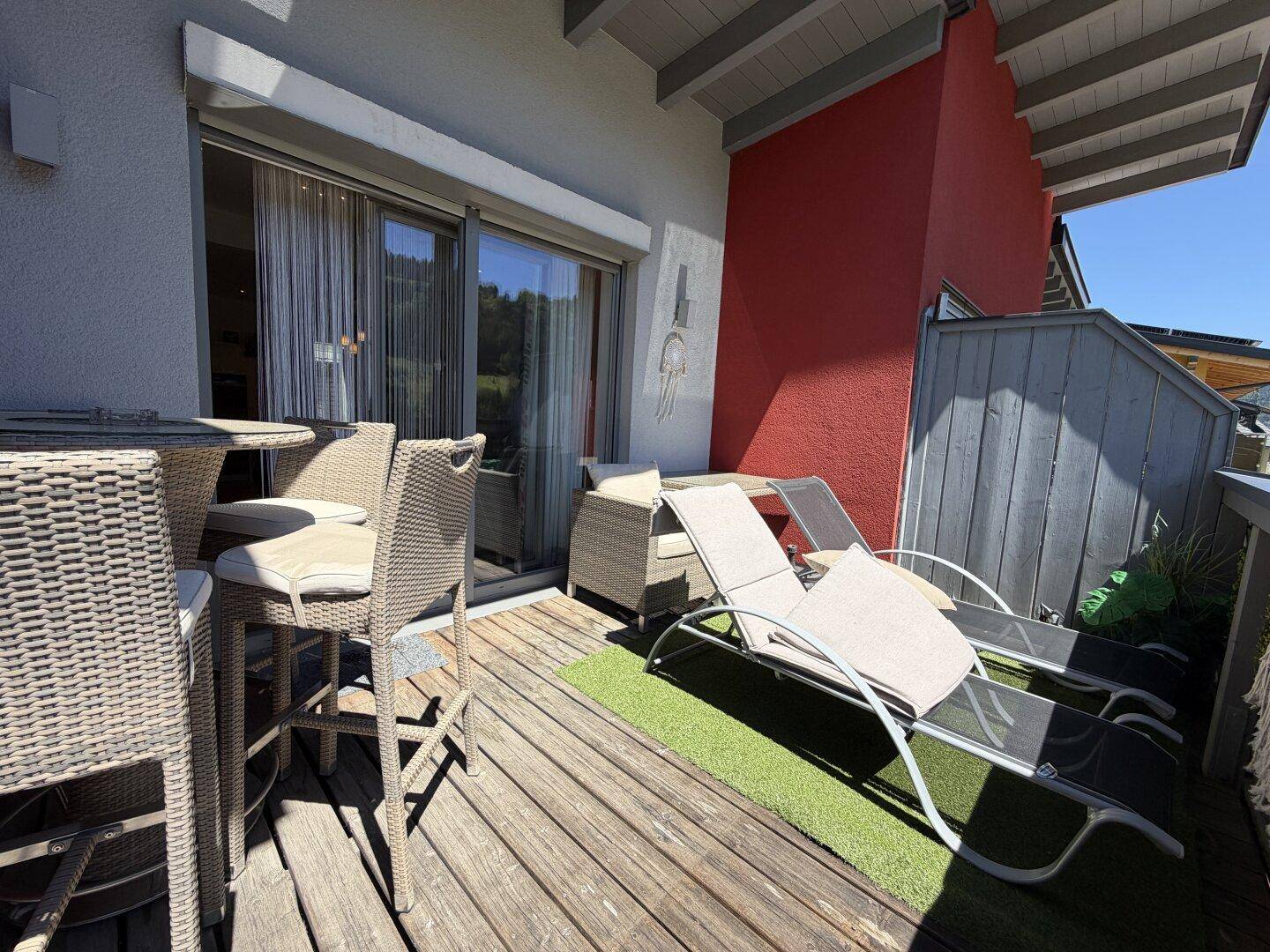 Gemütlicher Balkon mit Sitzgelegenheiten und Liegestühlen, perfekt für sonnige Stunden im Freien.