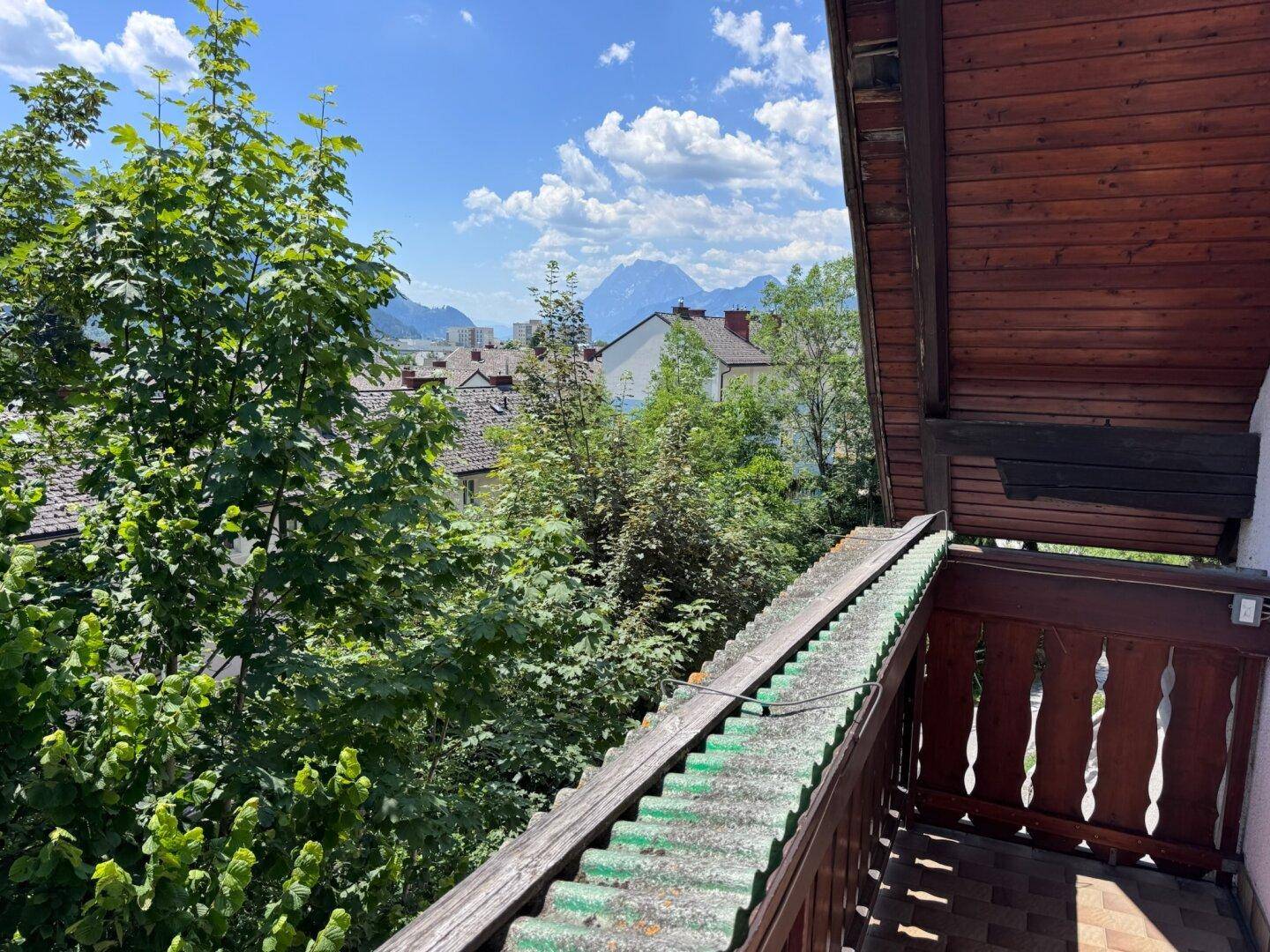 Balkon mit Holzverkleidung und Geländer bietet einen schönen Blick auf die Stadt und die Berge.