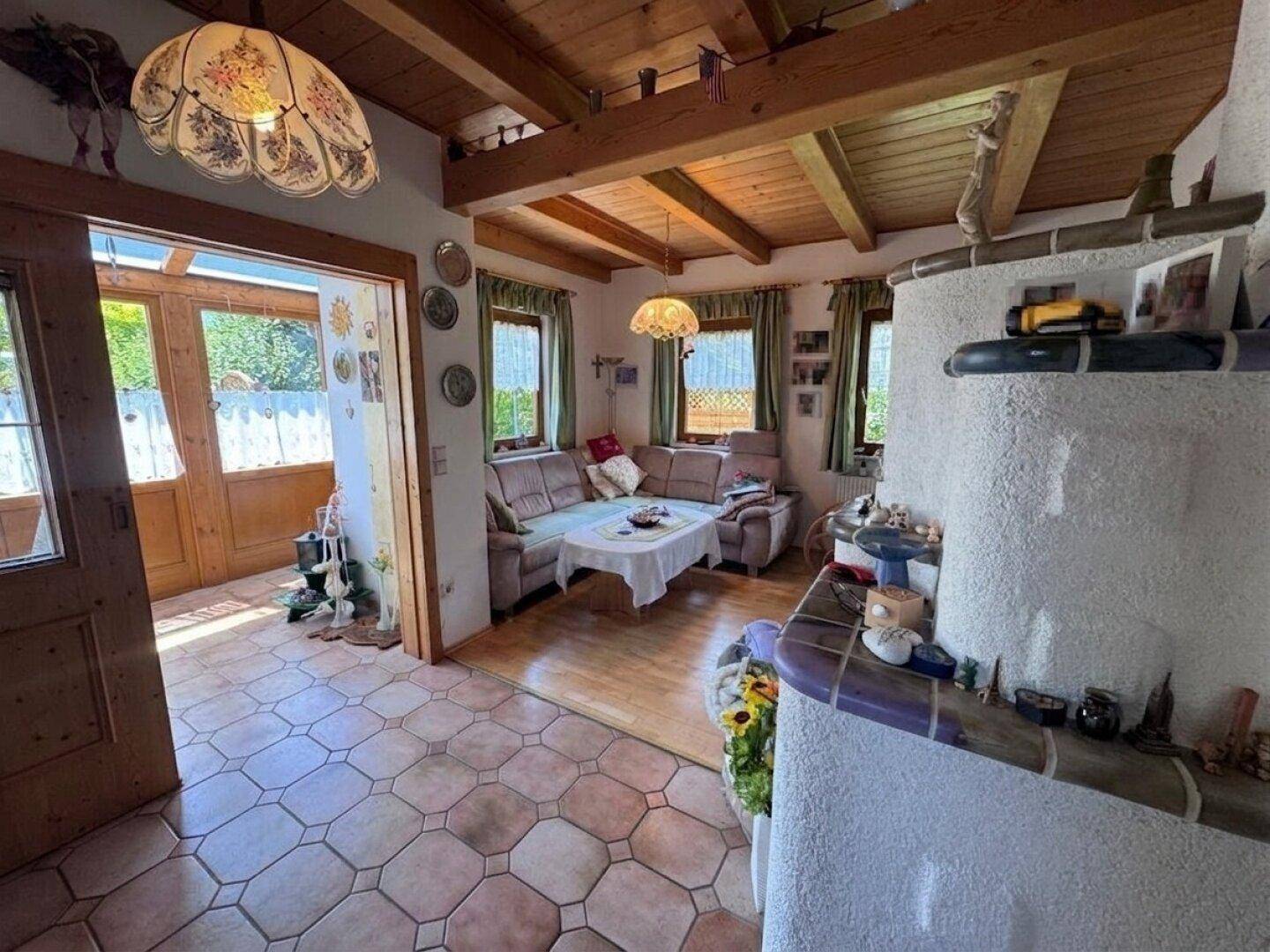 Traditionelles Wohnzimmer mit Kachelofen, Holzbalkendecke und rustikalem Charme.