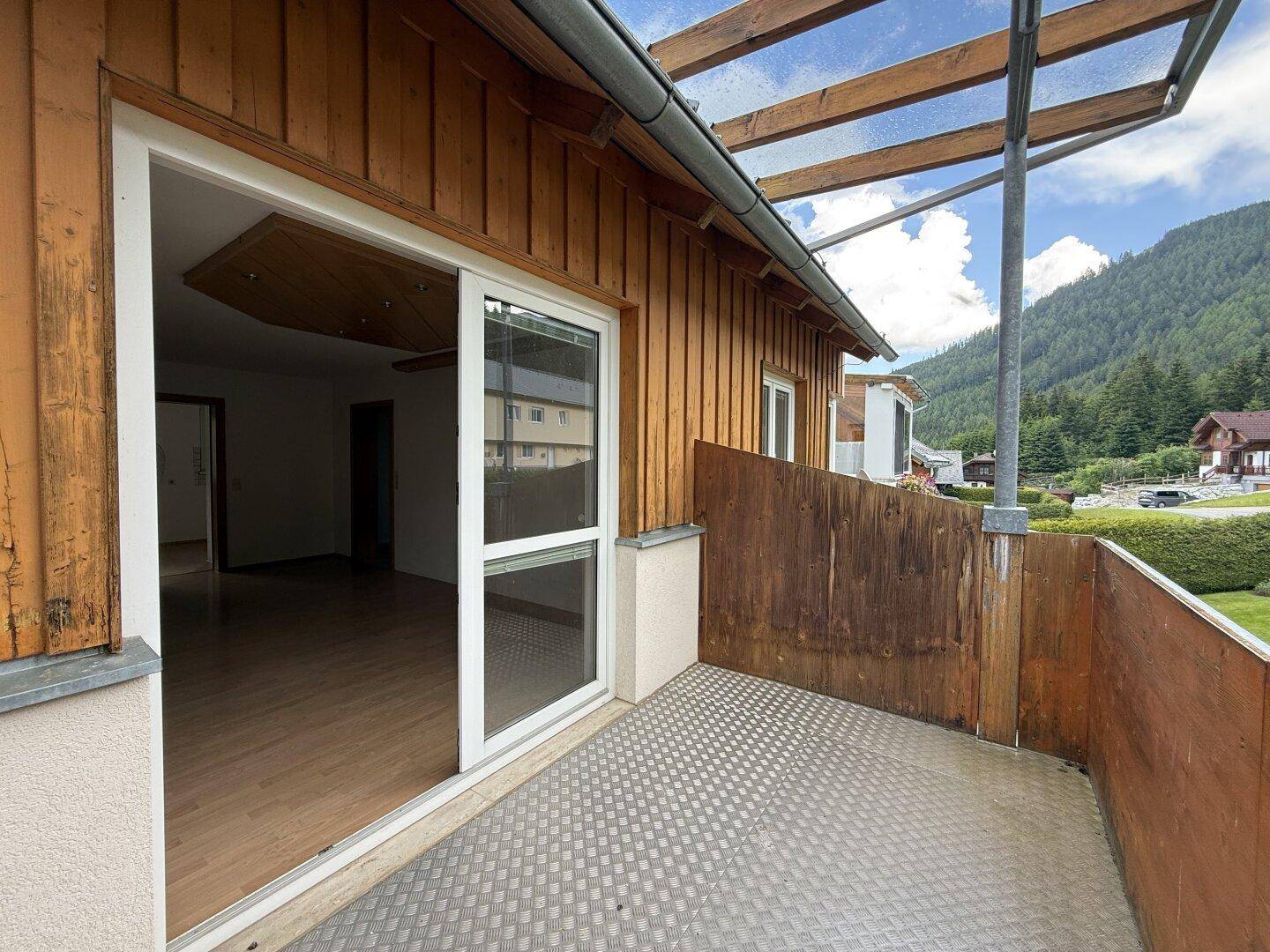 Geräumiger Balkon mit Holzelementen und Panoramablick auf die umliegende Natur und Berge.