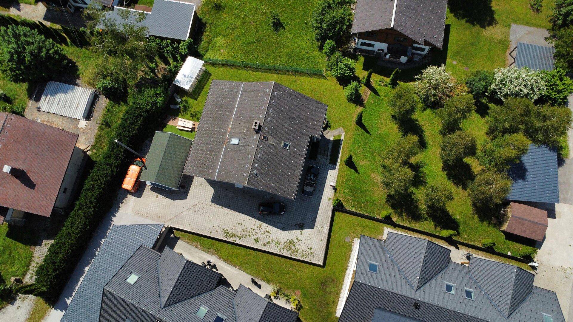 Luftaufnahme eines Hauses mit Garten und umliegenden Gebäuden in ländlicher Umgebung.