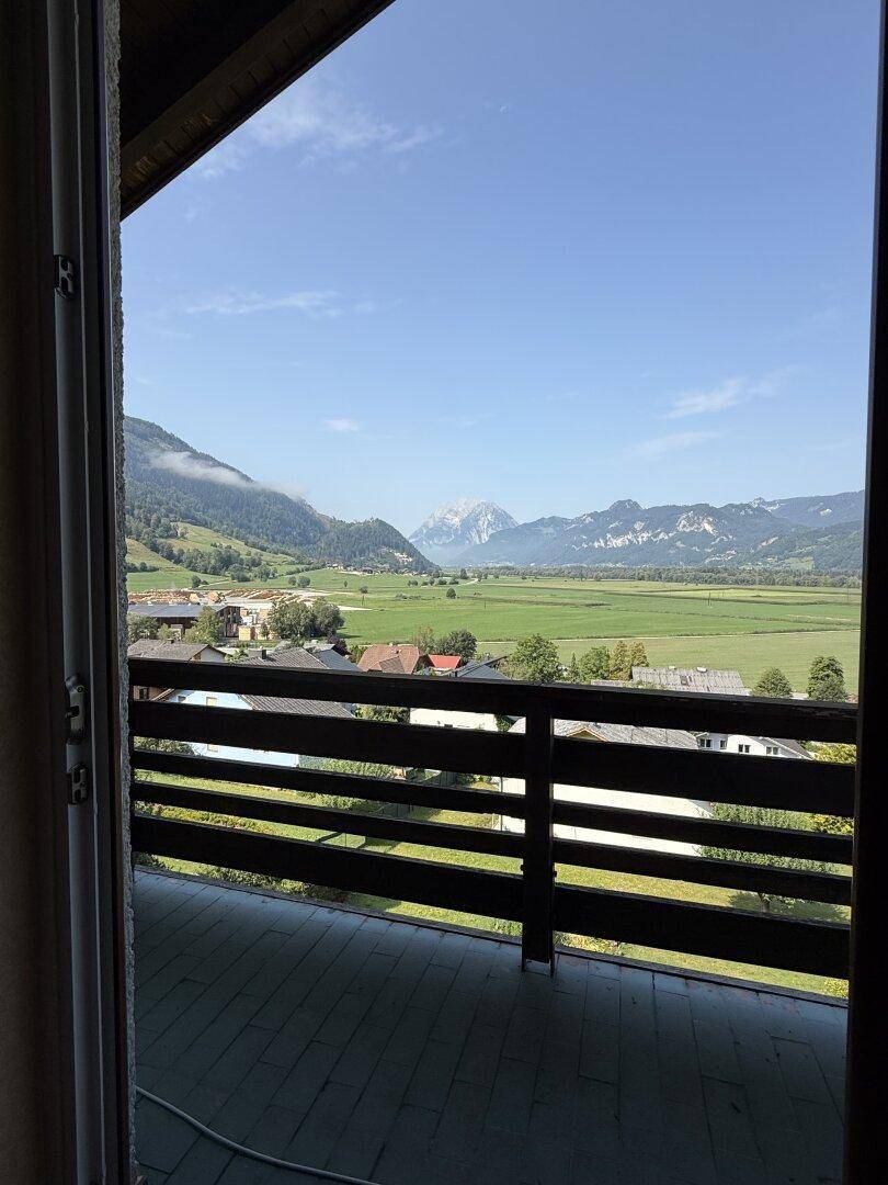 Blick aus einem Zimmer durch die Balkontür auf die weite Berglandschaft.