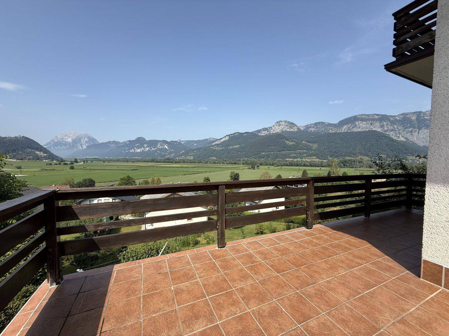 Weitläufige Terrasse mit Holzgeländer und unverbautem Panoramablick auf die umliegenden Berge.