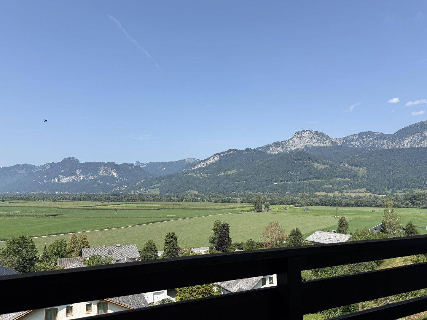 Panoramablick vom Balkon über die idyllische Landschaft mit Feldern und bewaldeten Bergen.