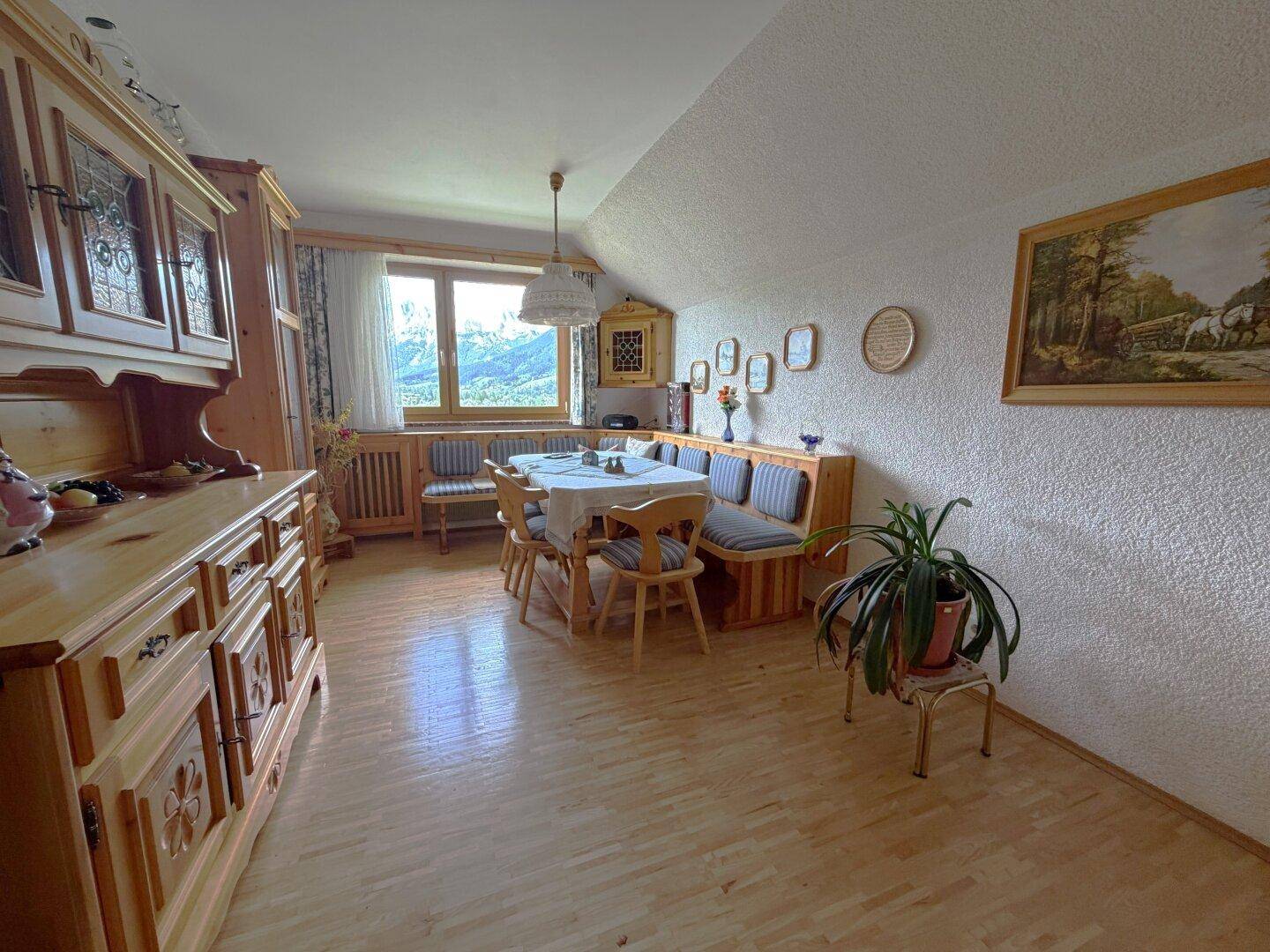 Gemütlicher Essbereich mit traditionellen Holzmöbeln, Eckbank und Blick auf die Berge.