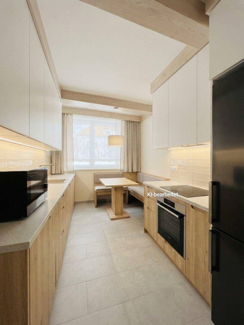 Moderne Küche mit Holzelementen, integrierten Geräten und gemütlichem Essbereich am Fenster.