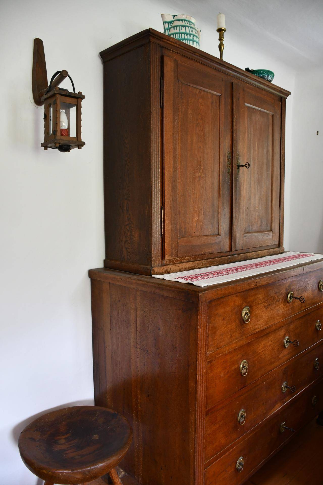 Antike Holzkommode mit passendem Schrank und traditioneller Dekoration.