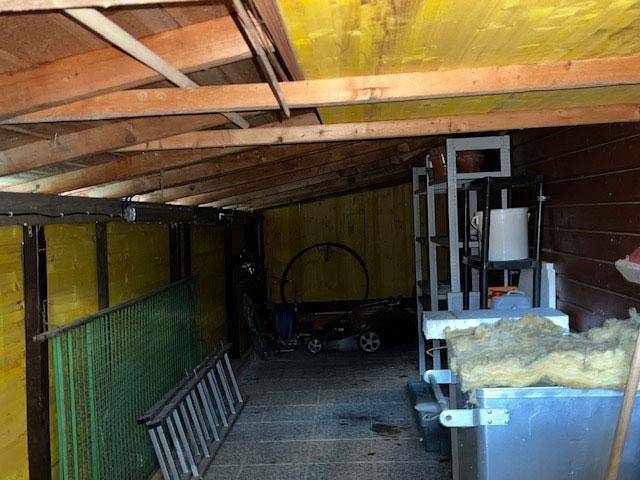 Geräumiger Werkstattbereich mit Holzverkleidung und Stauraum für Geräte und Materialien.
