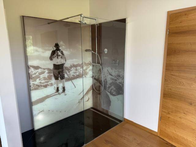Modernes Badezimmer mit großer begehbarer Dusche und alpiner Wandgestaltung.
