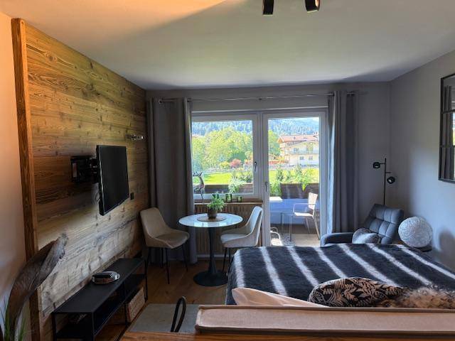 Gemütliches Schlafzimmer mit Holzakzenten, Balkon und weitem Blick in die Natur.