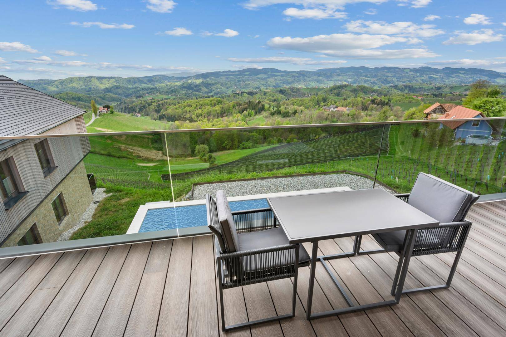 Geräumiger Balkon mit Sitzgelegenheiten und atemberaubendem Blick auf die Weinberge und den Pool.