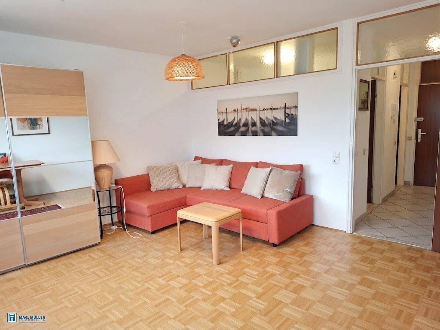 Gemütliches Wohnzimmer mit orangefarbenem Sofa, Parkettboden und dekorativer Beleuchtung.